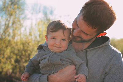 Portrait of smiling baby boy held by father