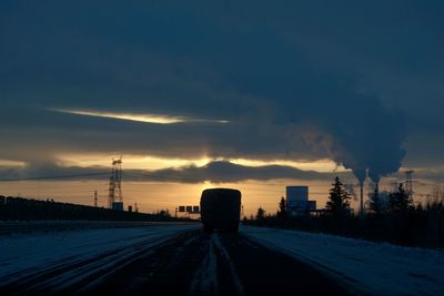 Smoke emitting from factory against sky during sunset