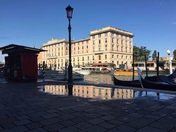 Boats moored in city against clear sky