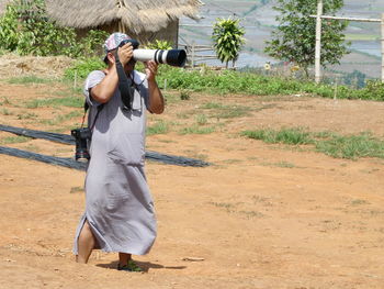 Man photographing with camera while standing on land