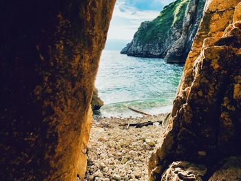 Scenic view of rocks on beach against sky