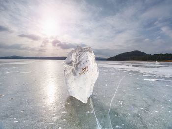 Ice breaking. floe on frozen lake with sunset sky background,