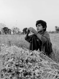 Portrait of young woman sitting on field