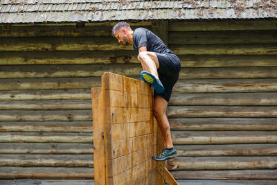 Man standing on wood against wall