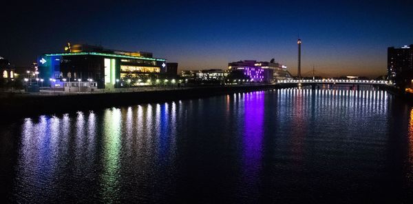 Illuminated buildings in city at waterfront