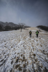 Rear view of people on snow covered land