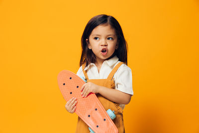 Girl making face holding skateboard