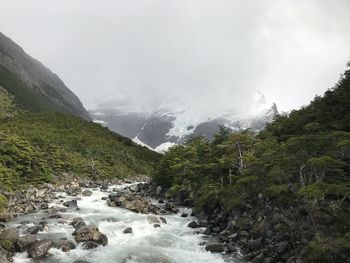 Scenic view of mountains and river against sky