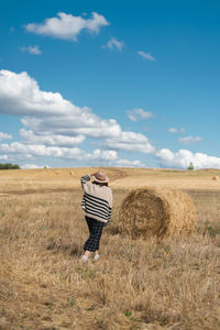 Woman standing on field against sky