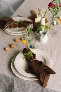 Vintage table setting with linen napkins and floral decorations. close up.