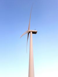 Low angle view of windmill against clear blue sky