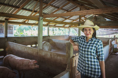 Portrait of female veterinarian smiling while standing in shed