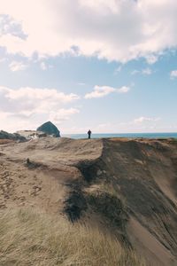 Mid distance of person standing at beach against sky