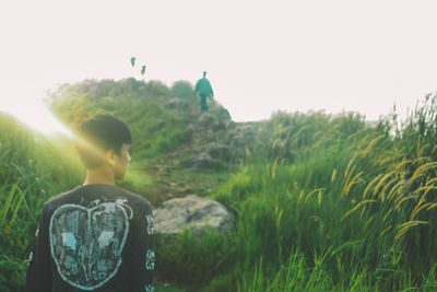 Rear view of man standing in front of plants