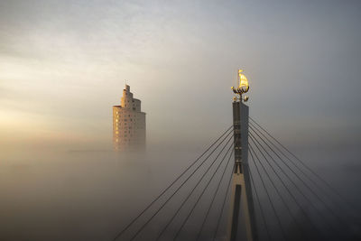 Tower bridge in city against sky during sunset