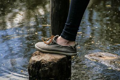 Low section of person standing by lake