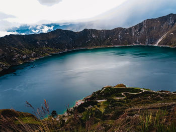 Scenic view of lake by mountains against sky