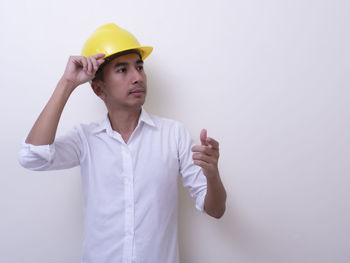 Young man wearing hat standing against white background