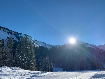 Scenic view of snowcapped mountains against blue sky