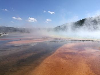 Scenic view of hot spring against sky