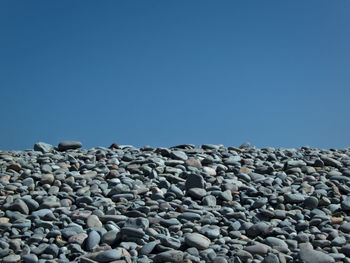 Surface level of stones against clear blue sky