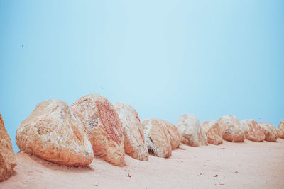 Rocks on beach against clear sky