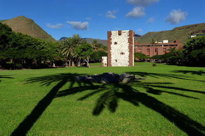 Built structure on field against blue sky