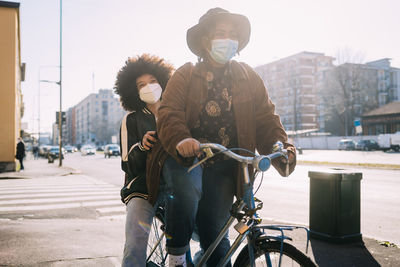 Young man riding bicycle on city street