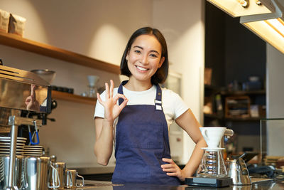 Portrait of young woman standing in cafe