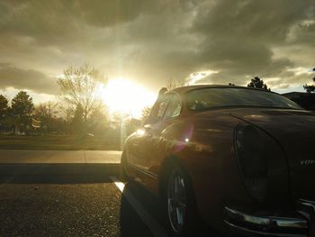 Cars on road against sky during sunset