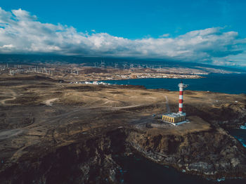 Lighthouse by sea against sky