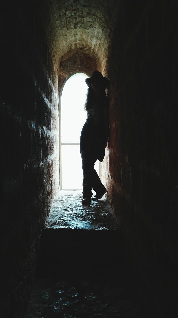 indoors, full length, lifestyles, tunnel, standing, arch, architecture, built structure, water, leisure activity, silhouette, rear view, men, walking, side view, reflection, person, sunlight