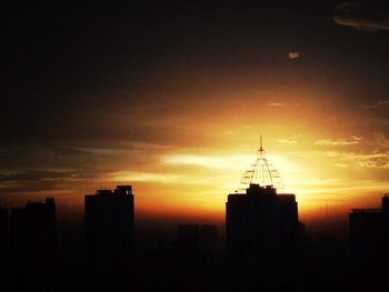 Skyscrapers in city at sunset