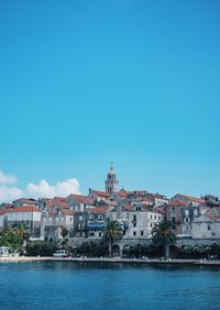 Buildings in city against blue sky