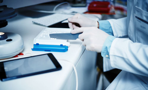 Midsection of doctor examining patient in laboratory