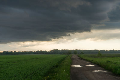 Scenic view of agricultural field against storm clouds