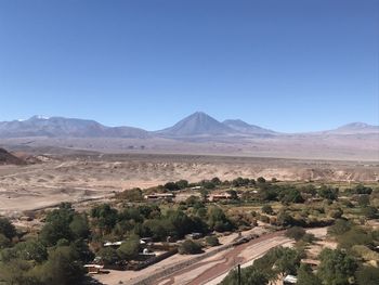 Scenic view of landscape and mountains against clear blue sky