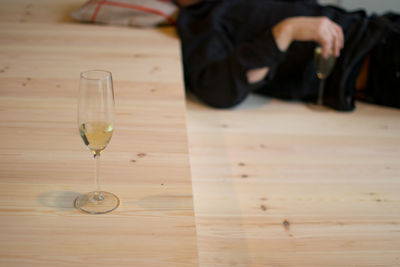 Champagne flute by man lying on floor