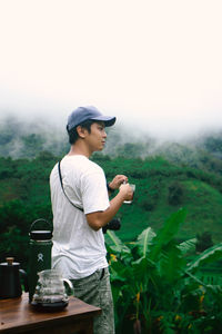 Full length of man looking away while standing outdoors