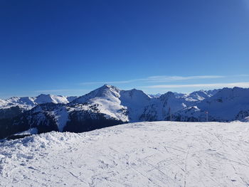 Scenic view of snowcapped mountains against clear blue sky