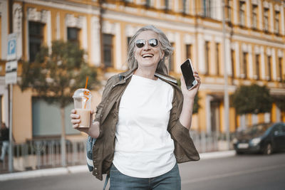 Young woman drinking in city