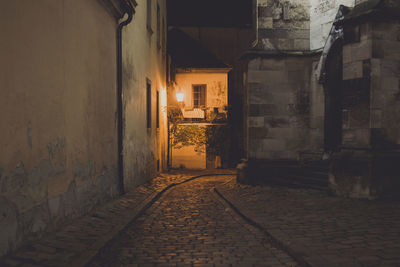 Alley amidst buildings in city at night