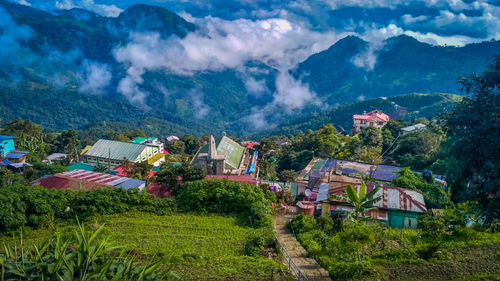 Scenic view of houses and mountains against sky