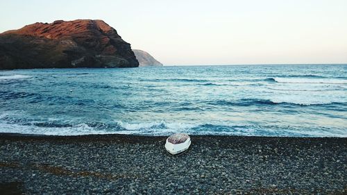 View of calm beach against clear sky