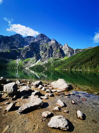 Scenic view of lake and mountains against blue sky