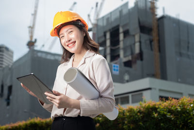 Young woman using phone while standing on camera