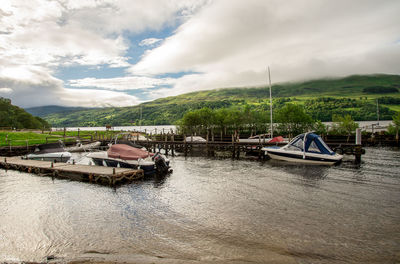 Boats moored on river against sky