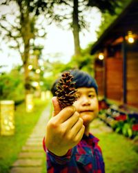 Portrait of boy holding plant