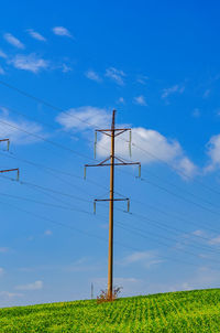 High voltage power lines. green grass, blue sky background. high voltage power tower