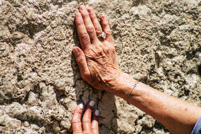 Close-up of person hand on rock